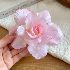 Detailed macro view of the delicate pink mesh fabric rose flower on a hair duckbill clip