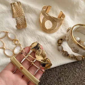 Detailed shot of gold-tone geometric bracelets with woven and marble textures