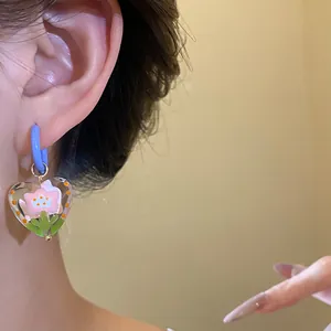 Close-up view of heart-shaped glazed flower pendant earring in sweet dopamine style