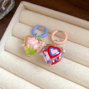 Close-up of sweet dopamine style glazed heart earrings with delicate floral motifs