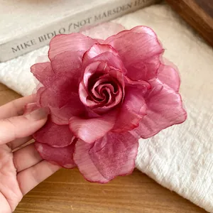 Macro view of the delicate layered mesh petals on this burgundy rose hair clip
