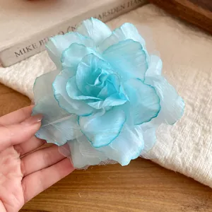 Close-up of elegant light blue fabric mesh flower hair clip with delicate petals