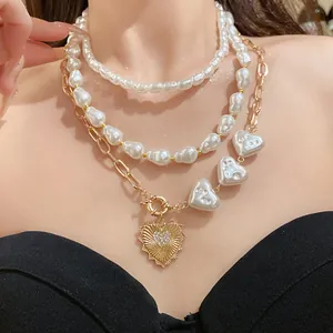 Primer plano de un collar de perlas de varias capas con un colgante de corazón brillante.