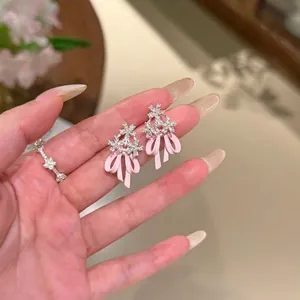 Exquisite Detailaufnahme von rosa Emaille-Schleifen-Ohrringen mit Zirkonia-Blumen
