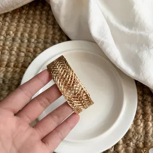 Detailed shot of a vintage gold woven open cuff bracelet with intricate braided texture