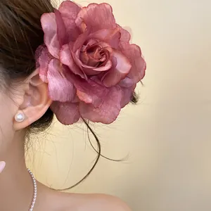 Detailed macro view of a large pink fabric rose mesh hair clip worn on an Asian model.