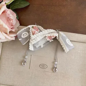 Elegant lace flower bow tassel earrings with crystal water drop pendants in a flat lay