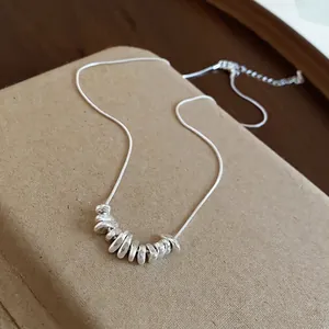 Minimalist silver-colored necklace featuring irregular pebble beads on a delicate snake chain