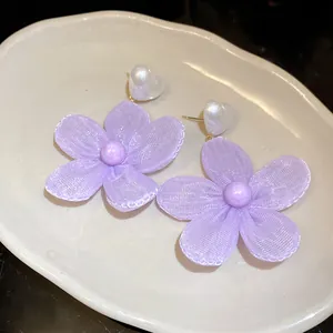 Close-up detail of sweet purple mesh camellia flower drop earrings with heart pearls