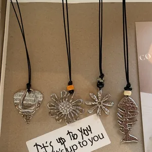 Set of vintage ethnic style necklaces with flower and fish bone pendants on black cords