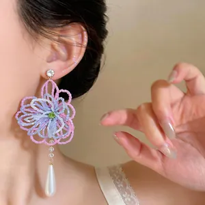 Boucles d'oreilles fleurs perlées avec pendentif perle pour un look chic et luxueux