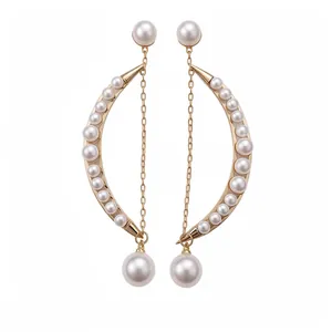 Elégantes boucles d'oreilles croissant de lune en or avec perles et détail pompon.