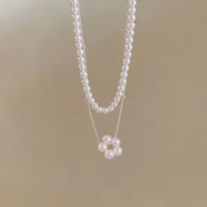 Elegante collana a doppio strato con filo di perle e un ciondolo a forma di fiore di perle