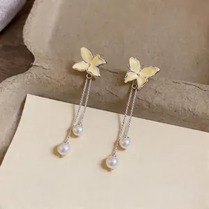 Elegant yellow enamel butterfly tassel earrings featuring white pearls on silver studs