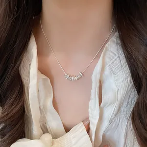 Close-up of minimalist silver necklace with irregular pendants on an Asian model
