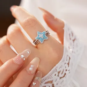 Macro detail shot of a silver star ring with turquoise pavé and zircon cross