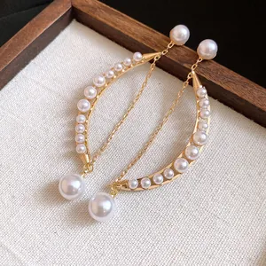 Boucles d'oreilles lune dorées élégantes avec perles et chaînes à pampilles fines.