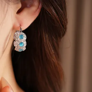 Macro detail of elegant blue cat eye stone hoop earrings accented with clear cubic zirconia