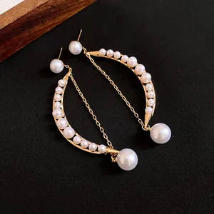 Gros plan macro détaillé de boucles d'oreilles rétro françaises en or avec croissant et perles