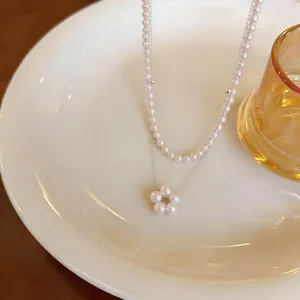 Dettaglio dell'elegante collana di perle a doppio strato con pendente a fiore