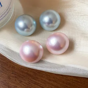 Detalle macro de pendientes de perlas iridiscentes azules y rosas en seda