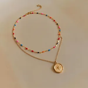 Double-layered gold necklace featuring colorful enamel beads and star engraved coin pendant
