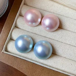 Primer plano de pendientes de perlas iridiscentes con un acabado metálico rosa y azulado