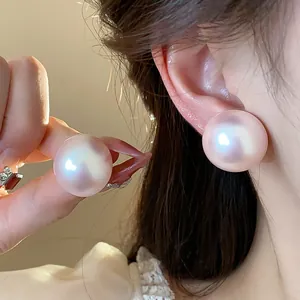 Primer plano de pendientes de perlas rosa iridiscentes que muestran elegancia y brillo