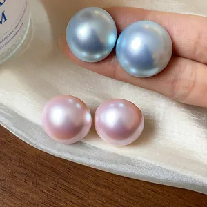 Primer plano de pendientes de perlas iridiscentes en tonos rosa y azul con brillo