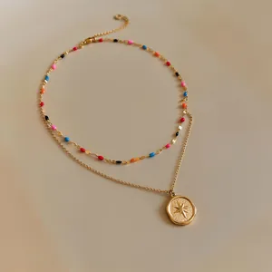 Macro view of a gold double-layered necklace featuring multi-color beads and star pendant.