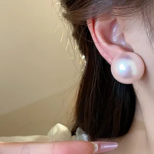 Primer plano de pendientes de perla rosa iridiscente de estilo francés elegante.