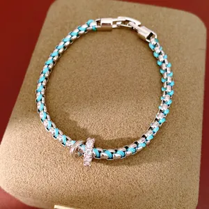 Nahaufnahme eines türkis-farbenen Armbands mit funkelnden Zirkonia-Anhängern
