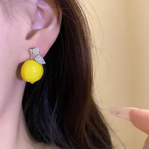 Detailed macro shot of a sparkling zircon lemon drop earring worn on a model's ear