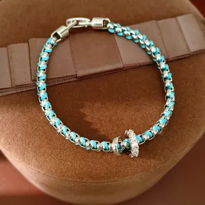 Detailansicht des blauen Armbands mit funkelndem Zirkonia-Ringanhänger.
