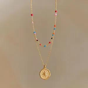 Elegant gold layered necklace featuring starburst pendant and vibrant colorful beads