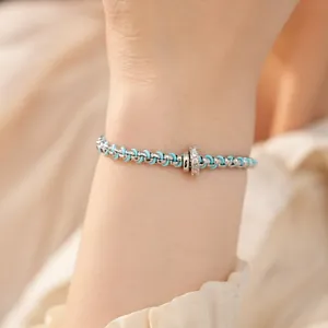 Detailansicht eines modischen hellblauen Armbands mit einem Zirkonia-Kreisanhänger