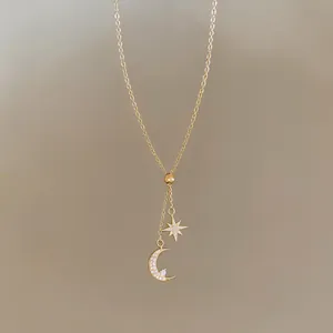 Detail view of an 18k gold plated necklace featuring a zircon encrusted moon and star pendant.