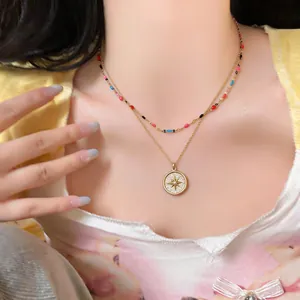 Detailed view of elegant gold double-layer necklace with star pendant and beads