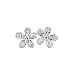 Élégantes boucles d'oreilles fleurs argentées avec pétales en cristal sur fond blanc.