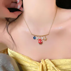 Macro view of a gold-toned necklace featuring a mushroom charm and pearl details