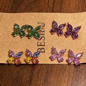 Detailed view of four pairs of colorful zircon flower stud earrings on a kraft card.