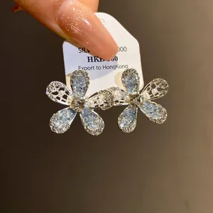 Gros plan détaillé de boucles d'oreilles fleurs en verre avec strass étincelants