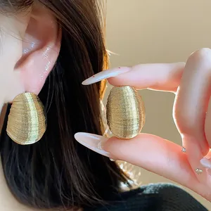 Detailed view of elegant gold textured oval stud earrings with metallic finish.