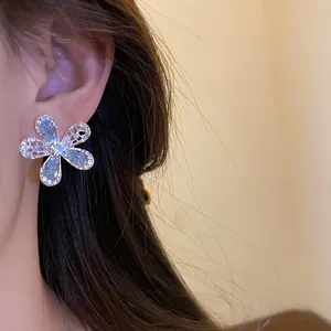 Gros plan de boucles d'oreilles fleurs argentées avec cristaux de verre étincelants