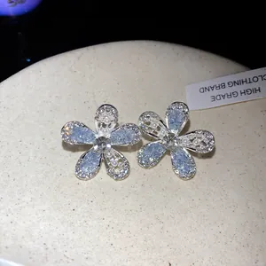 Détail de boucles d'oreilles en forme de fleur en argent avec cristaux scintillants