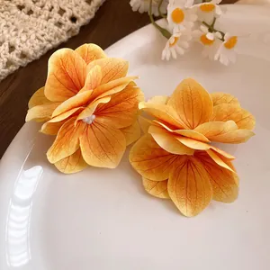 Primo piano di eleganti fermagli per capelli a fiore in tessuto arancione con venature