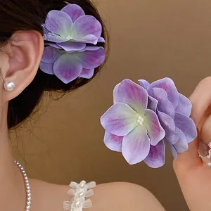 Vista dettagliata delle mollette per capelli a fiore in tessuto viola sul modello