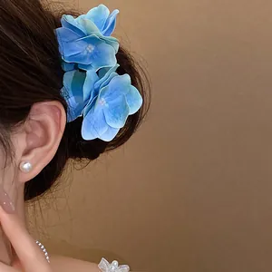 Vista dettagliata dell'elegante molletta per capelli a fiori di ortensia blu con perla