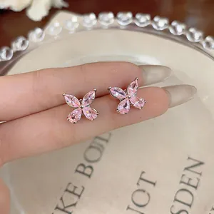 Macro detail of pink butterfly stud earrings with zircon stones and silver needles