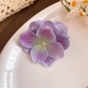 Dettaglio macro di un fermaglio per capelli a fiore di ortensia viola su un piatto